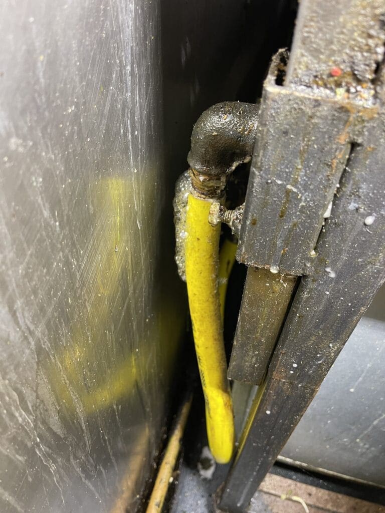 Commercial gas pipe repair in Norwich with damaged yellow gas pipework inspected for leaks