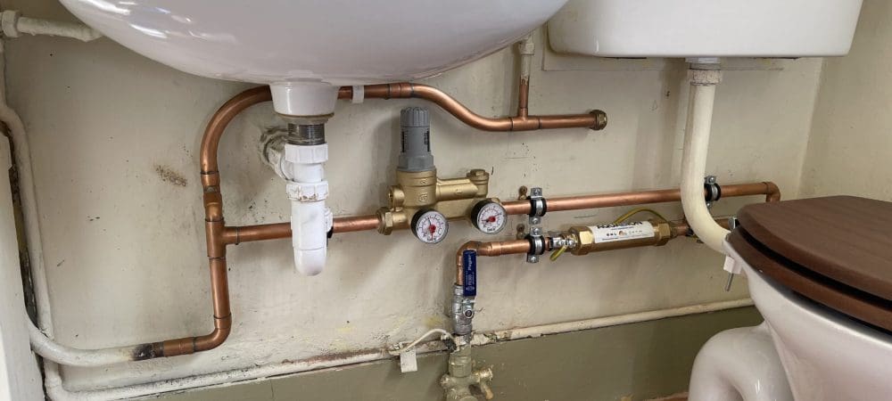 Plumber repairing pipework during a plumbing problem in a Brundall home